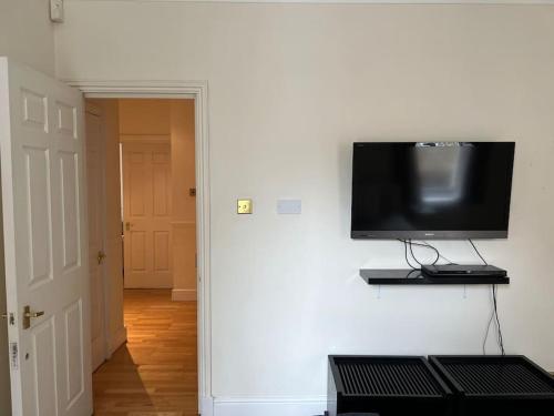 TV de pantalla plana colgada en la pared en Luxury 3 bedroom, 3 bath apt by Oxford St & Soho, en Londres