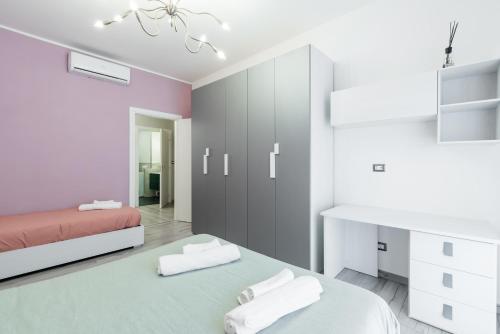 una camera bianca con due letti e un armadietto rosa e grigio di [5 min dal Centro] Cozy House a Torino