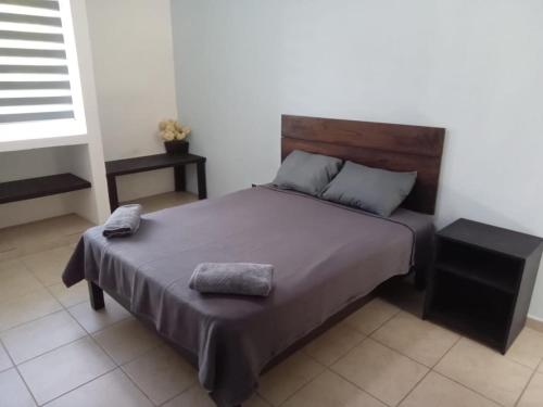 ein Schlafzimmer mit einem Bett mit zwei Kissen darauf in der Unterkunft Parque 44 in Playa del Carmen