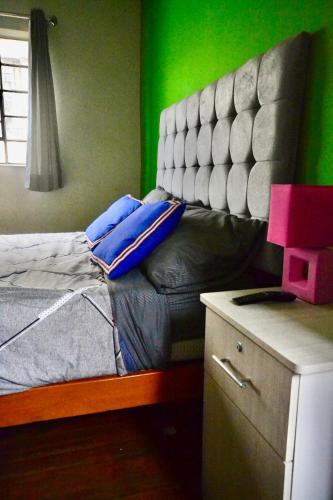 a bed in a room with a green wall at Maison Verte - Budget Edition in Arequipa