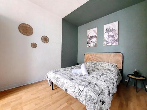 - une chambre avec un lit et deux photos sur le mur dans l'établissement Maison La Petite Bleue - Balcon - Wifi Fibre - Menage inclus, à Tarbes