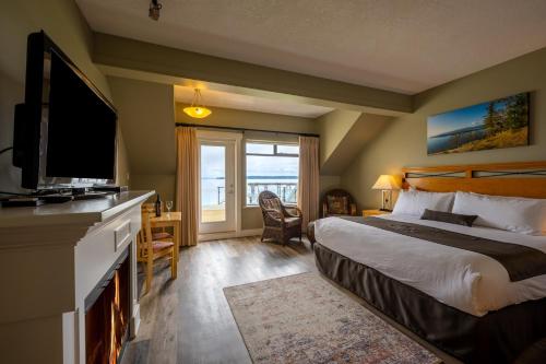 a hotel room with a bed and a television and a window at Sidney Waterfront Inn & Suites in Sidney