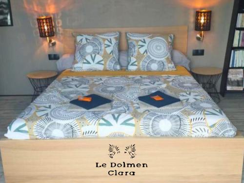 - un grand lit dans une chambre avec 2 tables dans l'établissement Le Loft du Dolmen Clara, entre terre et mer, à Plounévez-Lochrist