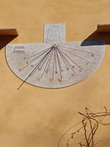 a clock on the side of a building at Casa Asilo La Foce, Val d' Orcia, Pienza. in Pienza
