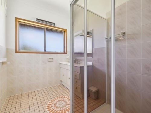 La salle de bains est pourvue d'une douche et d'un lavabo. dans l'établissement Gerry's Mullawarra Beach House, à Arrawarra