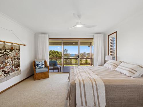 - une chambre avec un grand lit et un balcon dans l'établissement Gerry's Mullawarra Beach House, à Arrawarra