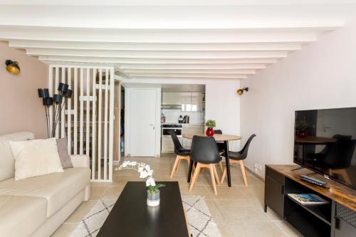 een woonkamer met een bank en een tafel bij Rivoli Vieille du temple in Parijs