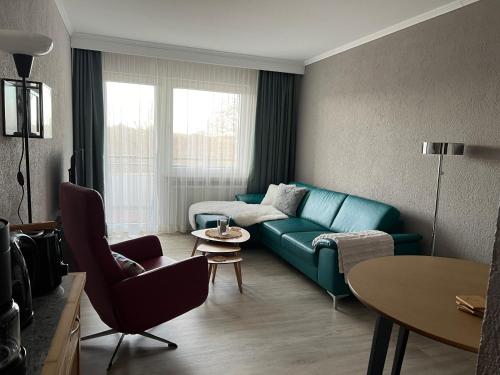 a living room with a blue couch and a table at Fi-Suiten in Waldeck