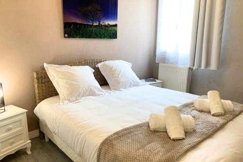 1 dormitorio con 1 cama con sábanas y almohadas blancas en Henri en scène, en Chartres