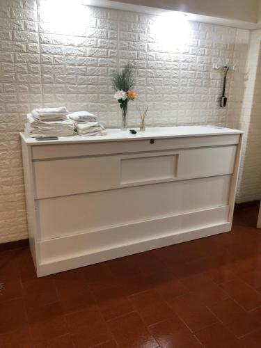 a white counter with a vase of flowers on top at King & Queen in Buenos Aires