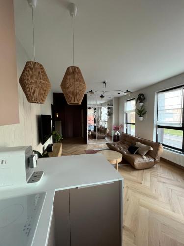 a kitchen and living room with a white counter top at WIDOKI3 Apartment Montownia Foodhall in Gdańsk