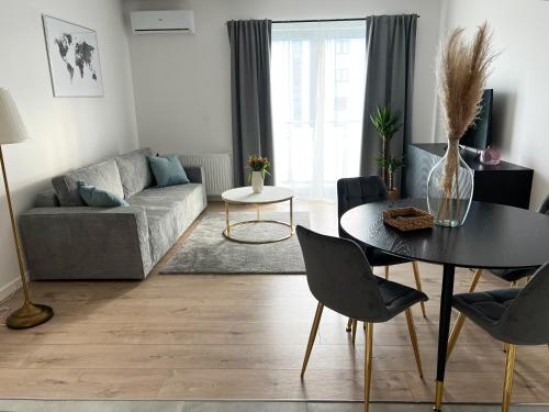 a living room with a table and a couch at Apartament nad Iławką MIRANDA centrum in Iława