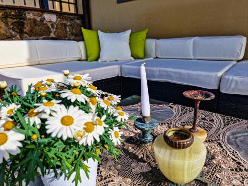 a living room with a couch and flowers on a table at Villetta dei Fagiani - B&B in Montauto