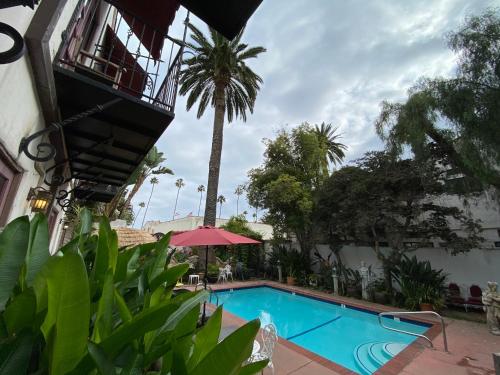 a swimming pool in front of a building with a palm tree at TIDE POOL VILLAS in Santa Barbara