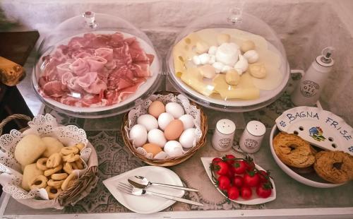LatianoMasseria Cortese的桌子上摆放着装满食物的篮子，里面有鸡蛋和其他食物。