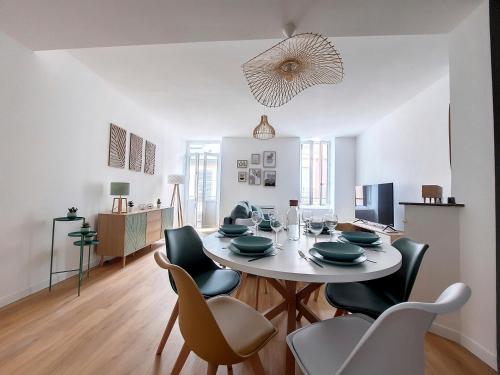 une salle à manger avec une table et des chaises blanches dans l'établissement Le Nordique - 2 chambres - Fibre Wifi - Netflix - Ménage inclus, à Tarbes