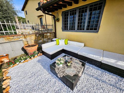 a patio with a white couch and a table at Villetta dei Fagiani - B&B in Montauto