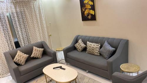 Happiness Place في King Abdullah Economic City: غرفة معيشة مع أريكة وطاولة