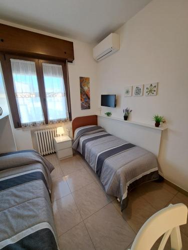 1 dormitorio con 2 camas y TV en Le Terrazze Rooms en Ferrara
