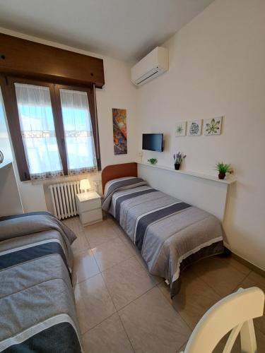 a bedroom with two beds and a tv at Le Terrazze Rooms & Studios in Ferrara