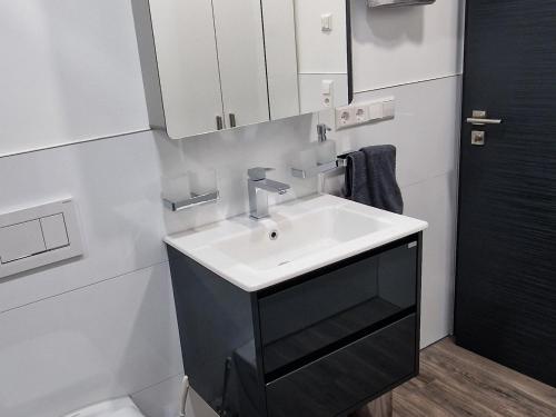 a white bathroom with a sink and a mirror at Haus Ludwig in Freudenstadt