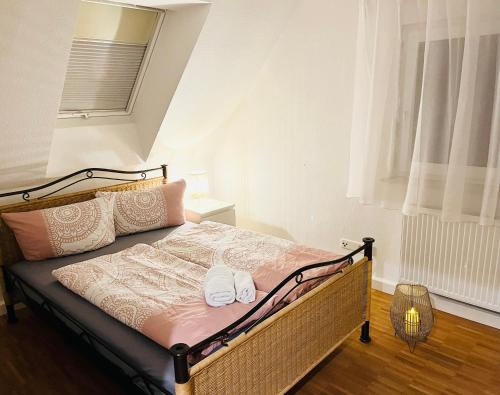SEEMOMENTE nahe Messe, Spieleland, Friedrichshafen في ميكنبورن: غرفة نوم عليها سرير وعليها حذان ابيض