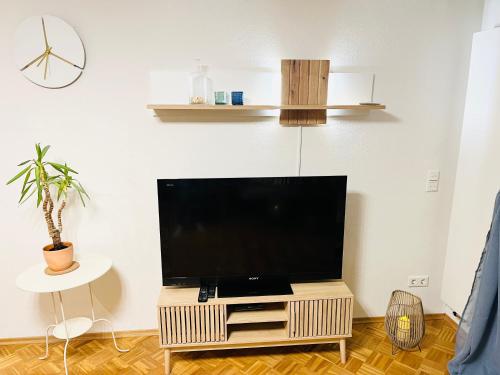 a flat screen tv on a stand in a living room at SEEMOMENTE Spieleland, Messe, Friedrichshafen 3 Zi mit Balkon, Parkplatz in Meckenbeuren