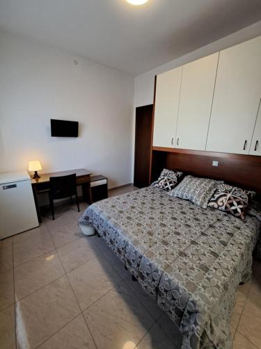 a bedroom with a bed and a desk and a television at Le Terrazze Rooms & Studios in Ferrara