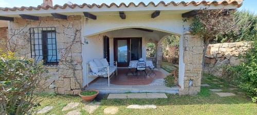 una casa in pietra con patio arredato con tavolo e sedie di Lupo 1 a Cannigione