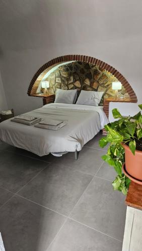 a bedroom with a large bed with a stone wall at Cuevas CEMAR in Guadix