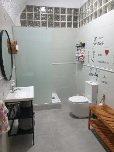 a white bathroom with a toilet and a sink at Cuevas CEMAR in Guadix
