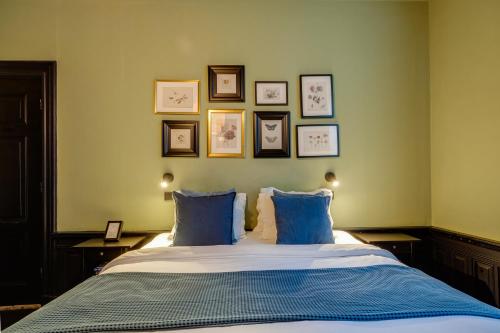 a bedroom with a bed with blue pillows and pictures on the wall at SeventyFive in Amsterdam