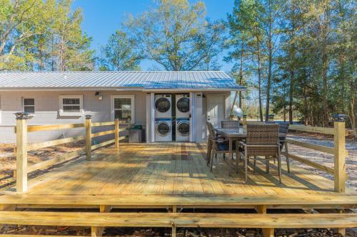 a deck with a table and chairs and a house at Westville Pines Cabin in Westville