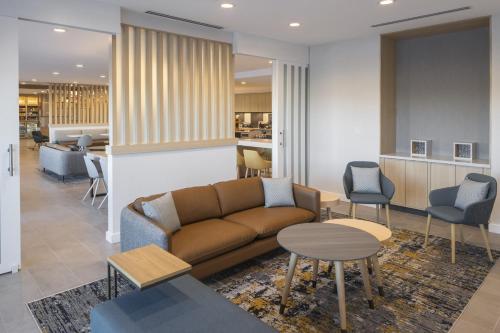 a living room with a couch and tables and chairs at TownePlace Suites by Marriott Georgetown in Georgetown