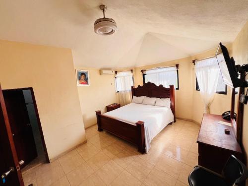 a bedroom with a bed and a desk and windows at Constellation Hotel 3 in Dajabón