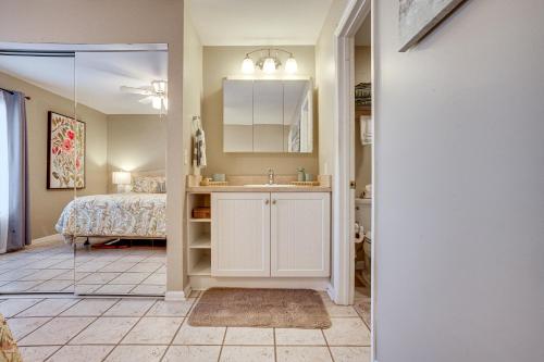 a bathroom with a sink and a bedroom with a bed at Harbor Island Condo with Deck - Steps to Beach! in Oceanmarsh Subdivision