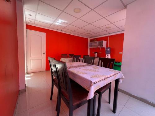 comedor con paredes rojas, mesa y sillas en Hotel Casa del profesor Iquique, en Iquique