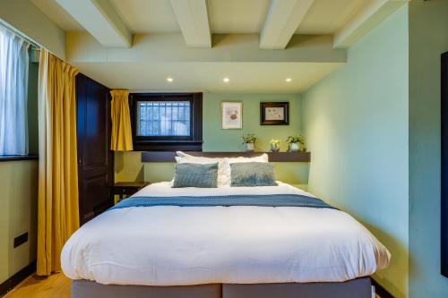 a bedroom with a large bed with yellow curtains at SeventyFive in Amsterdam