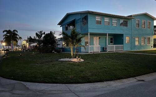 a blue house with a palm tree in the front yard at Lovely vacation home 1 block from beach & downtown Gulfport in St. Petersburg
