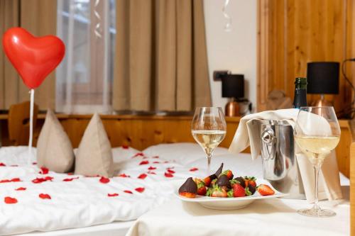 a table with a plate of food and wine glasses at Hotel Galli in Livigno