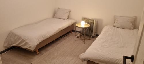 a room with two beds and a table with a lamp at Spacious 2 Bedroom Apartment with Court yard - Antwerp Smooth Stays in Antwerp