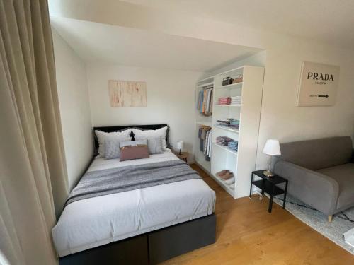 a small bedroom with a bed and a couch at Premium Studio Grafenberg in Düsseldorf