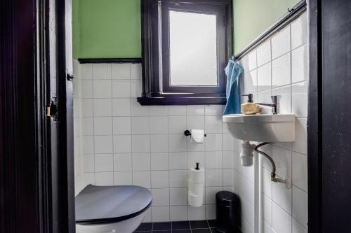 a bathroom with a toilet and a sink and a window at SeventyFive in Amsterdam