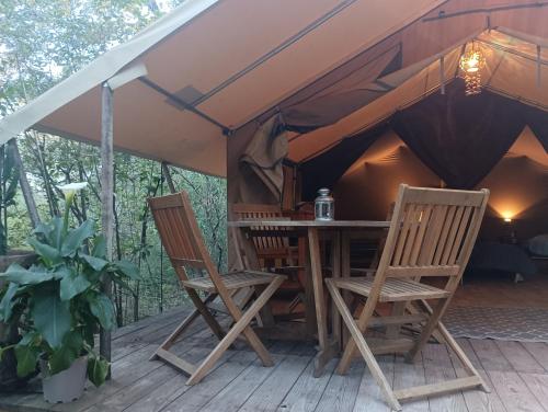 加爾水道橋的住宿－Tente safari au Pont du Gard，帐篷配有两把椅子和一张桌子,位于甲板上