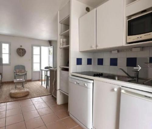 une cuisine avec des armoires blanches et un comptoir dans l'établissement Maison front de mer La Flotte, à La Flotte