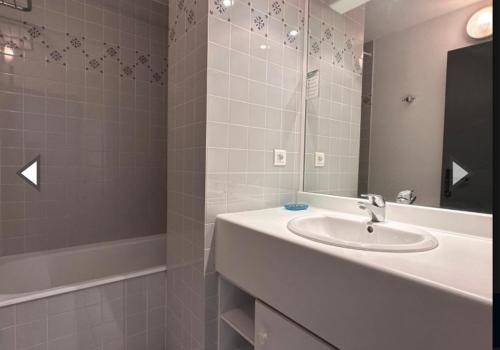ein Badezimmer mit einem Waschbecken, einem Spiegel und einer Badewanne in der Unterkunft Maison front de mer La Flotte in La Flotte