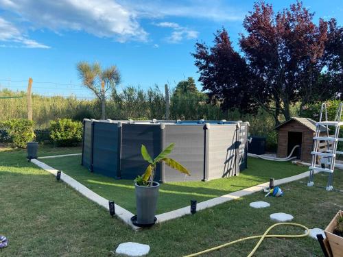 a small shed in a yard with a plant at Villa SPA Proche Ardeche Ruoms-Vallon pont d'Arc et sites in Ruoms