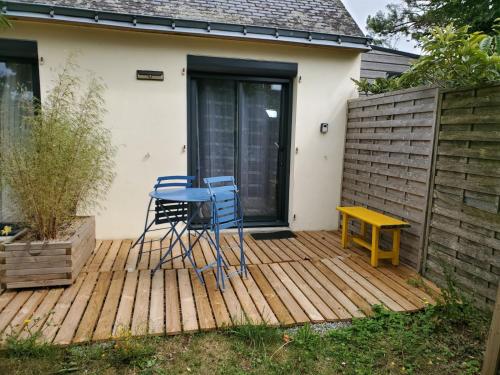 two chairs and a table on a wooden deck at Studio au calme, dans village tranquille in Séné