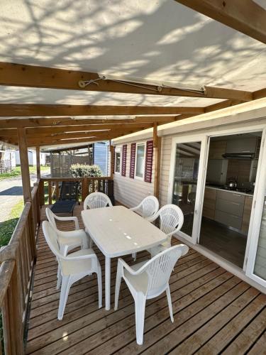 a wooden deck with a table and chairs on it at Le Neptune in Argelès-sur-Mer