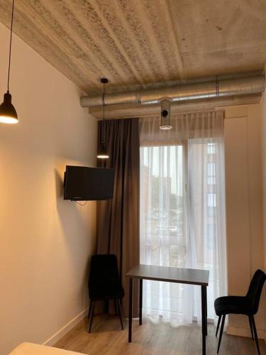 ein Wohnzimmer mit einem Tisch und einem Fenster in der Unterkunft Apartment Loftas13-7 in Kretinga